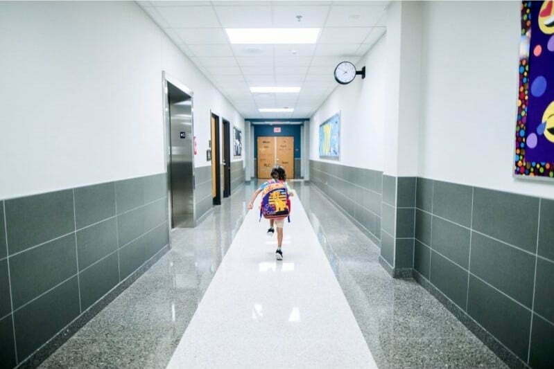 A little boy is walking down the hallway