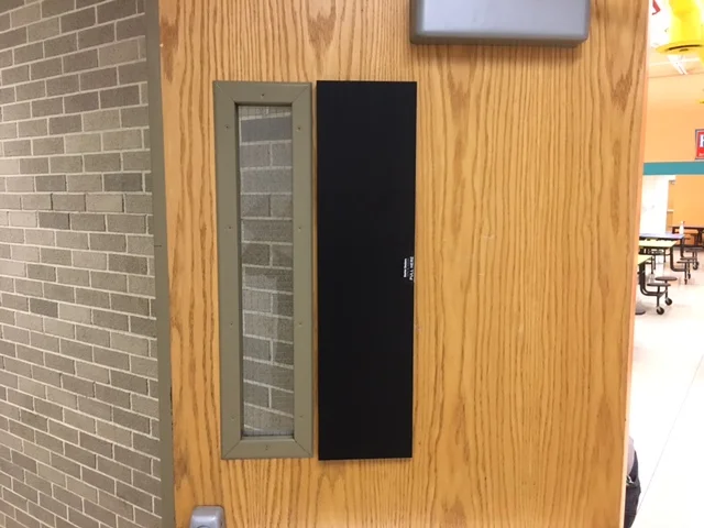 A door with a window and a small black screen.