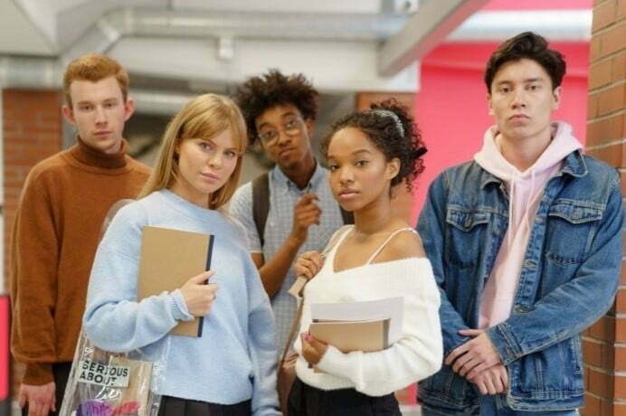 A group of people standing together holding books.