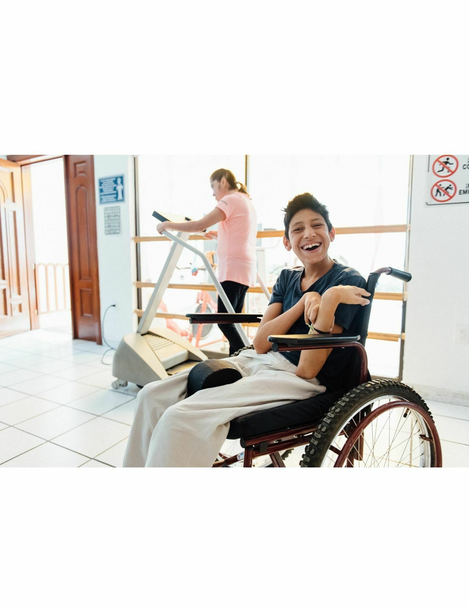 A woman in a wheelchair is smiling at the camera.