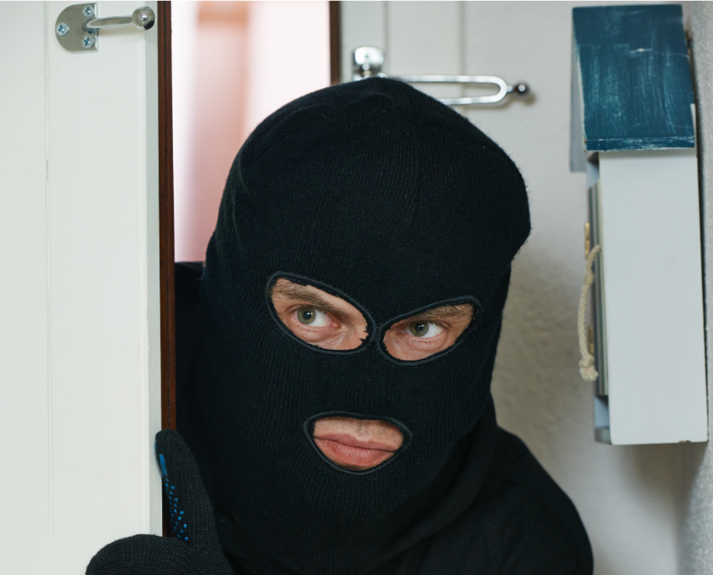A person wearing a black mask and looking at the camera.
