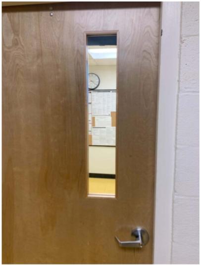 A door with a mirror in it and the door handle.